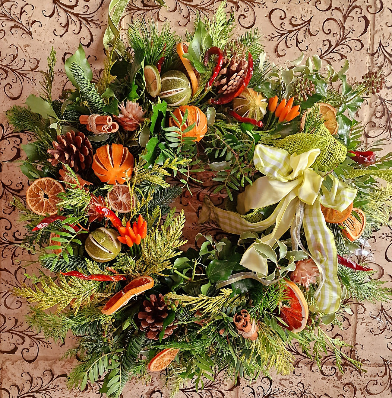 Citrus and cinnamon Christmas wreath with dried fruit, cones and mixed greenery.